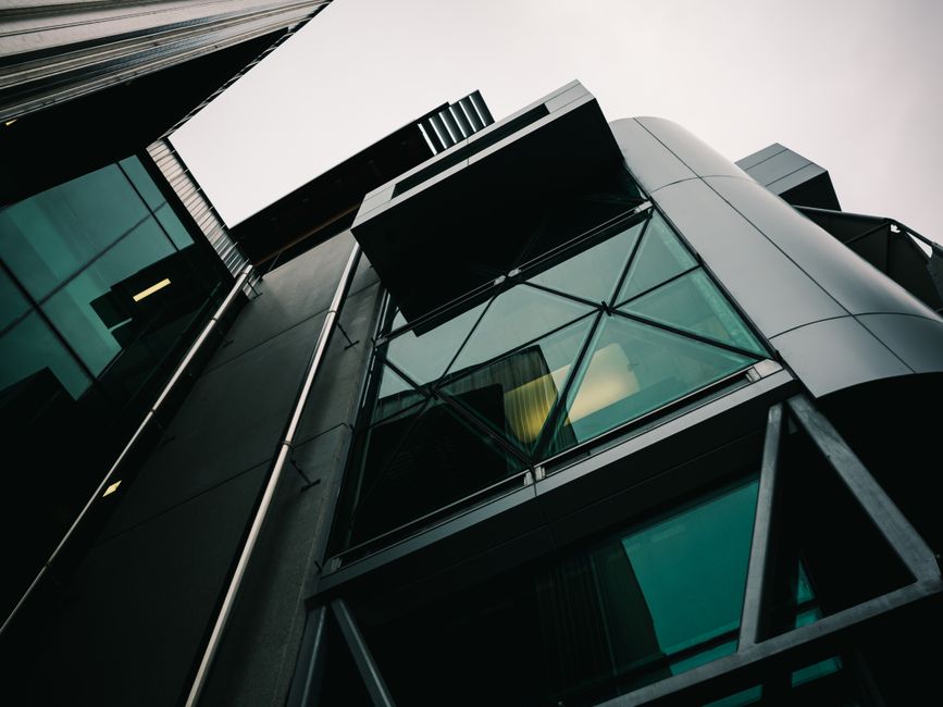 Vista de bajo ángulo de un edificio moderno con diseño geométrico de vidrio y metal