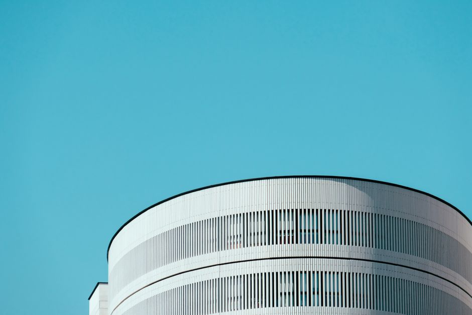 Diseño arquitectónico minimalista con edificio cilíndrico bajo un cielo azul despejado