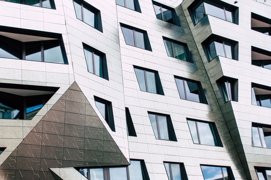 Fachada moderna de edificio con formas geométricas y ventanas reflectantes