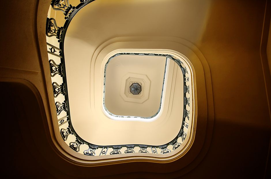 Escalera en espiral con diseño artístico y tragaluz