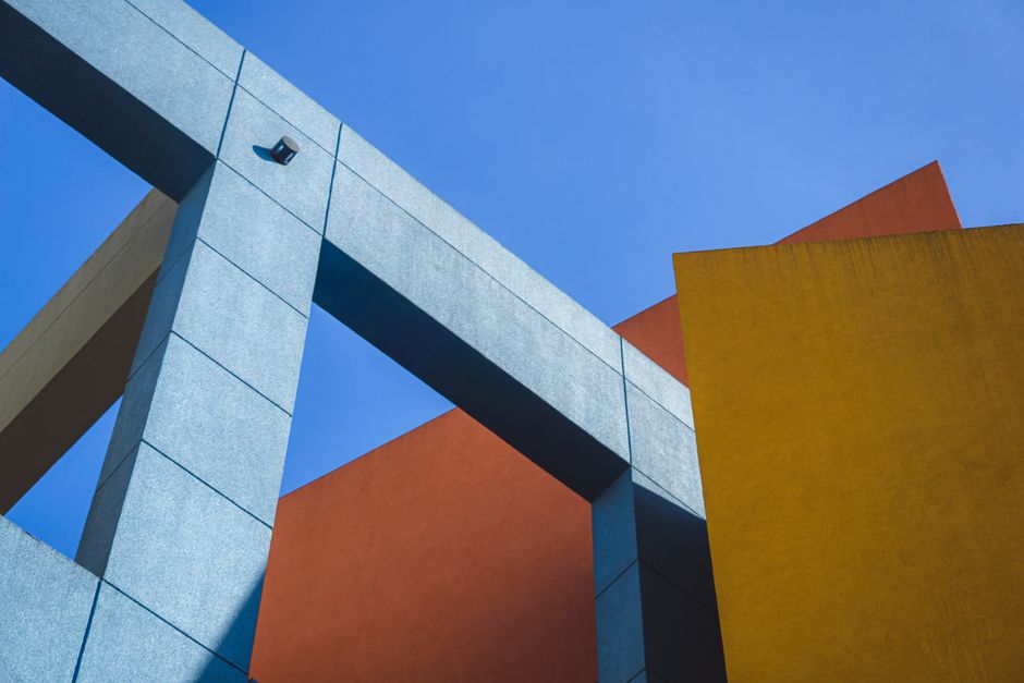 Toma dinámica de arquitectura geométrica colorida contra un cielo azul despejado